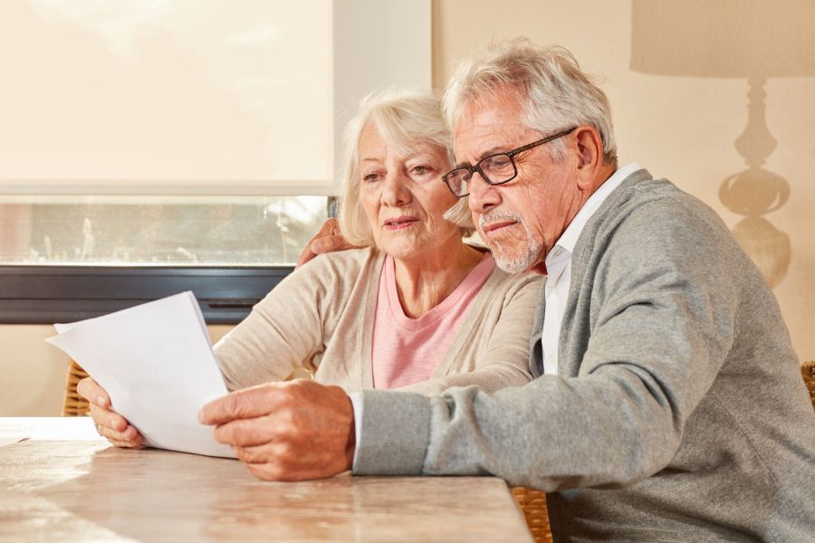 Dos personas mayores repasando documentos del banco